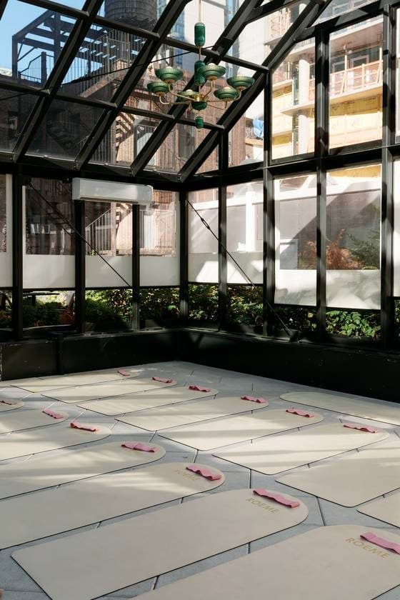 Roeme mats and pink bands set up in the corner of the Virgin Hotels greenhouse