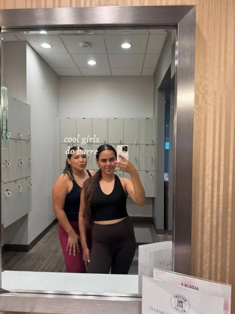 Two creators in workout clothes taking a locker room mirror selfie, captioned cool girls do barre