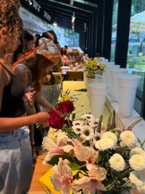 Creators arranging bouquets at a flower bar lined with fresh blooms