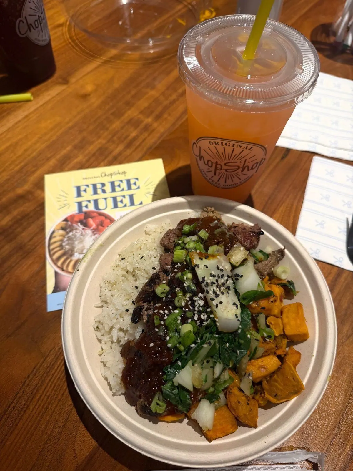 Original ChopShop rice bowl with steak and sweet potatoes beside an iced juice
