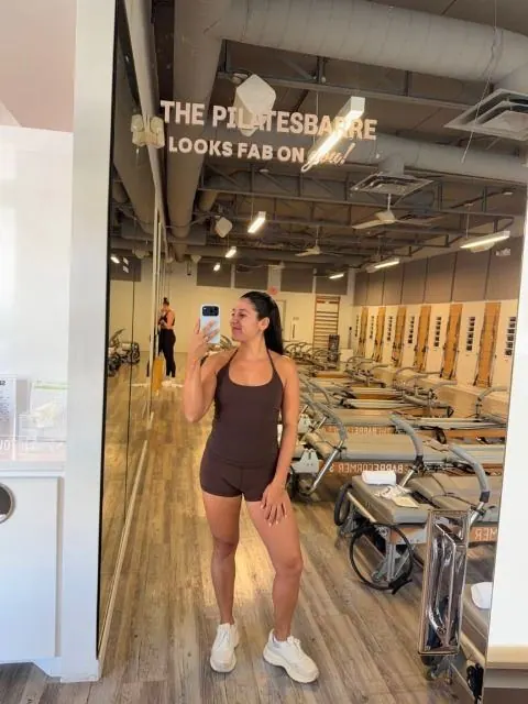 Creator taking a mirror selfie in the reformer room at The PilatesBarre